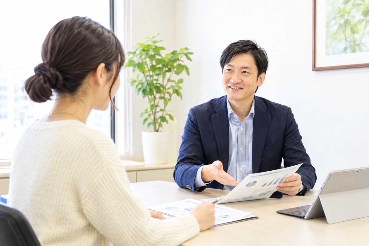 株式会社Erwinの相談窓口で、FPが資料を示しながら女性のお客様に住宅ローンと資金計画を説明している様子